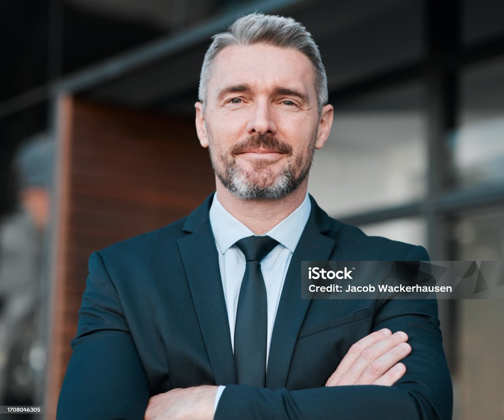 istockphoto-1708046305-1024×1024 Business man, mature and portrait outdoor with arms crossed for professional career and positive attitude. Face of entrepreneur or CEO person with pride, confidence and ambition or corporate growth
